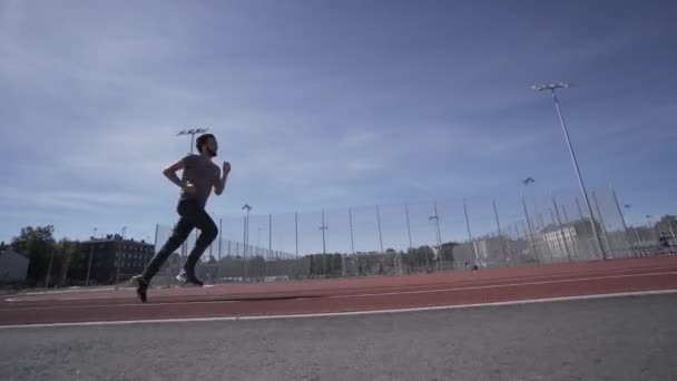 Fitnessmann läuft auf rotem Stadionmodell Sommerlauf — Stockvideo