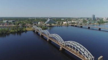 Köprü Riga şehir raylı yollar Slowmotion drone uçuş ile araçların trafik air uçuş daugava Nehri üzerinde bridge yakınındaki tren