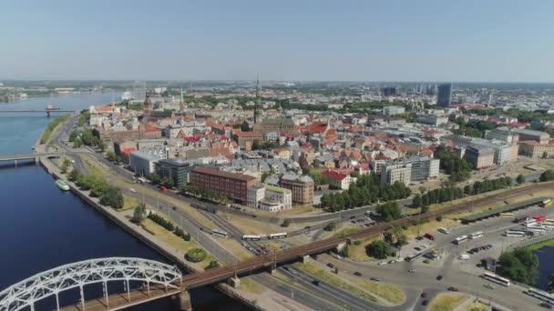 Puente de tren en la ciudad de Riga Vieja vías férreas Slowmotion drone Vuelo cerca del puente con el tráfico de coches vuelo aéreo sobre el río daugava — Vídeos de Stock