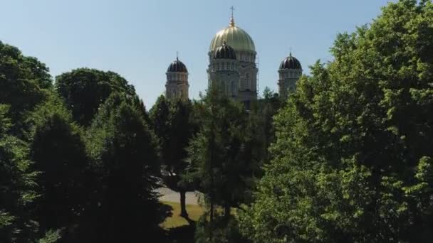 Iglesia en la ciudad de Riga histórica Europa casas de pueblo y edificio con carreteras y coches de tráfico vuelo Drone — Vídeos de Stock