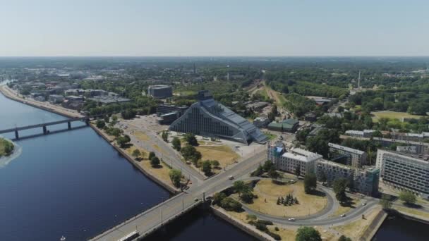 Vieja ciudad de Riga nueva biblioteca Slowmotion drone Vuelo cerca del puente con el tráfico de coches vuelo aéreo por encima del río daugava — Vídeo de stock