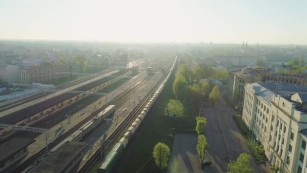 Trein brug en spoor wegen met trein in Riga stad Slowmotion drone vlucht in de buurt van brug met auto verkeer air-vlucht boven — Stockvideo