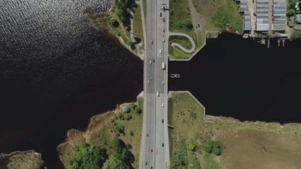 Viaducto del Puente de Carreteras en la ciudad de Riga y edificio con tráfico de carreteras y coches Vuelo Drone cerca del agua — Vídeos de Stock