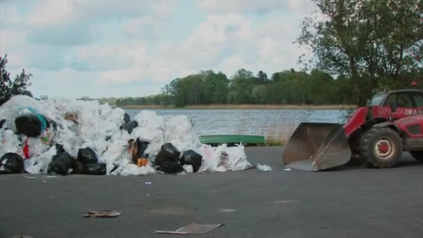 Excavadora elimina papel de basura y botellas de plástico para el reciclaje — Vídeo de stock