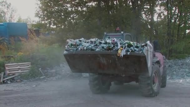 Экскаватор удаляет мусорную бумагу и пластиковые бутылки для переработки — стоковое видео