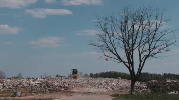 Escavatore rimuove carta straccia e bottiglie di plastica per il riciclaggio — Video Stock