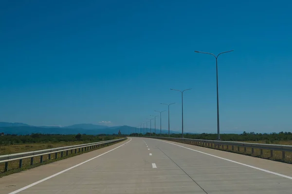 Road trip uitzicht vanaf de auto asfalt en blauwe hemel — Stockfoto