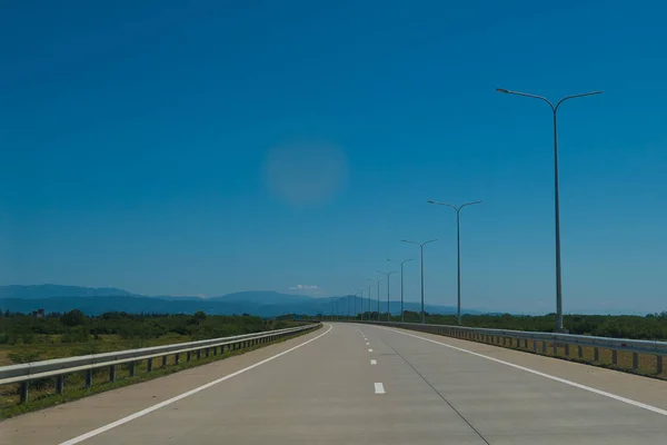 Road trip uitzicht vanaf de auto asfalt en blauwe hemel — Stockfoto