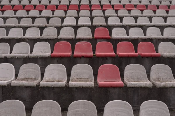 Alte Stadionstühle, die früher nicht mit Staub in rot und weiß benutzt wurden — Stockfoto