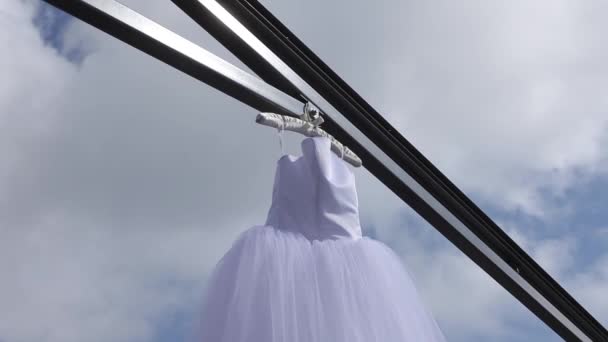 Weißes Hochzeitskleid hängt an einem Kleiderbügel — Stockvideo