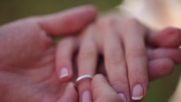 Anéis de casamento macro closeup Colocando o anel em seu dedo ouro branco jóias de diamantes — Vídeo de Stock