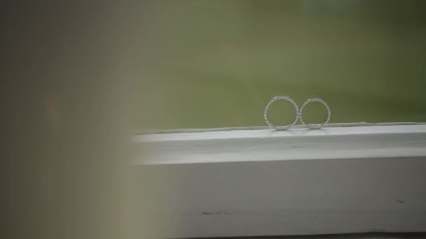 Весільні срібні кільця на вікні макро крупним планом знімають діамант Ювелірні вироби — стокове відео