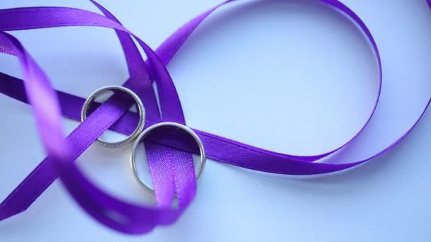 金色的结婚戒指紫色丝带宏观特写拍摄 diamon 首饰 — 图库视频影像