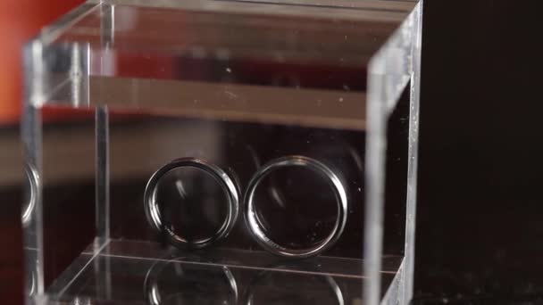 Серебряные обручальные кольца в стеклянной коробке — стоковое видео