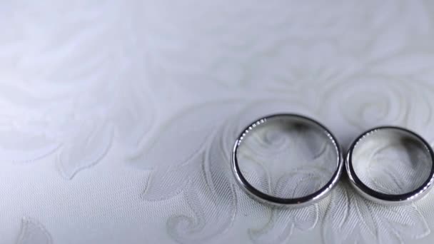 Серебряные обручальные кольца на столе макросъемка крупным планом бриллиантовые украшения — стоковое видео
