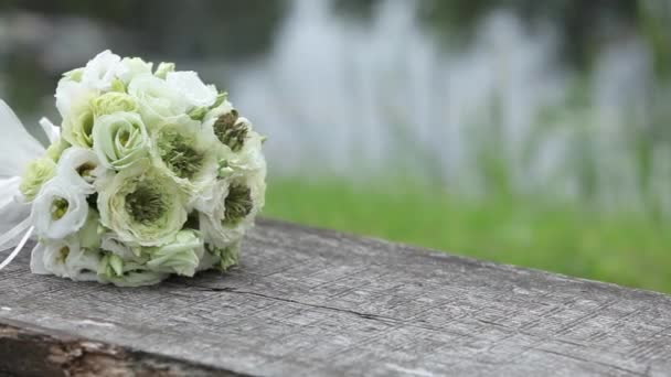 Bílá svatební kytice, venku na dřevěné lavici — Stock video