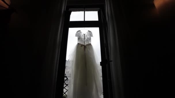 Weißes Hochzeitskleid, das in den Fenstern auf dem Balkon hängt und gemauerte Szenen — Stockvideo