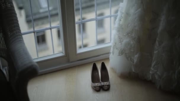 Біла весільна сукня та взуття вдома біля вікна — стокове відео