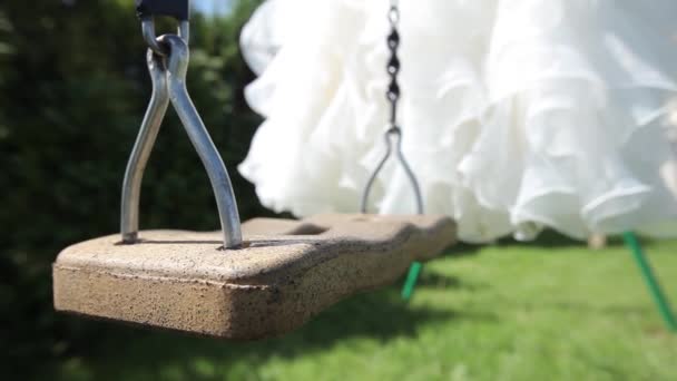 Abito da sposa bianco appeso su un'altalena verde in giardino — Video Stock