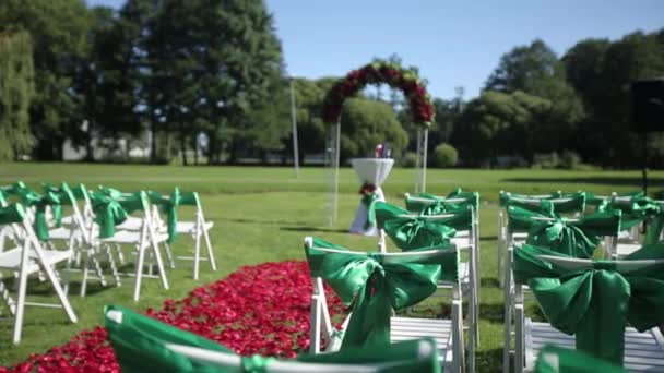 Çiçekler ve süs eşyaları ile açık bir törenle yeşil düğün sandalye — Stok video