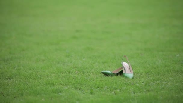 Свадебная свадьба красивые туфли зеленые туфли на зеленом поле уксус каблуки крупным планом — стоковое видео