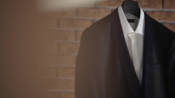 A mans kavaj och kostym hänger på en galge innan de hästskötare bröllop — Stockvideo