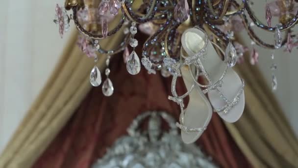 Свадебная свадьба красивые туфли висят на винтажной лампе в солнечных лучах отражений роскошь каблуки крупным планом — стоковое видео