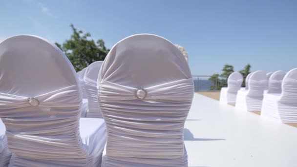 Lugar da cerimônia de casamento e cadeiras decoradas Decorações de casamento para a noiva Bijouterie, fitas, decorações de cetim e jóias — Vídeo de Stock