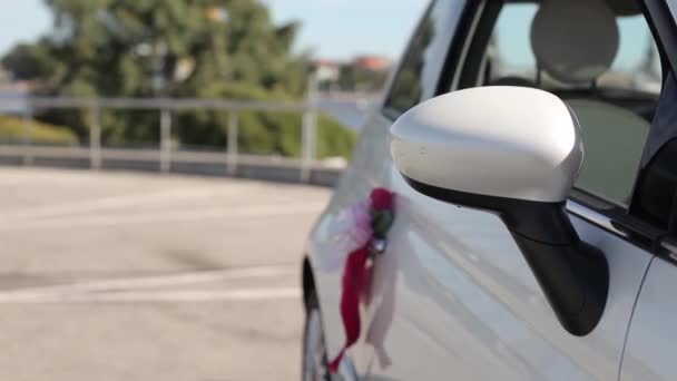 White wedding car Red flowers hang by car — Stock Video