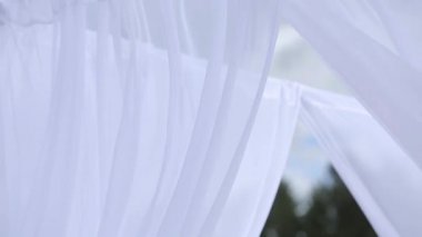 Beyaz kumaşlar ve çiçek törenden önce sahilde düğün süslemeleri