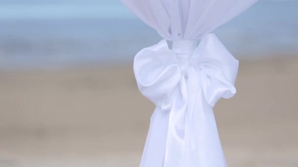 Весільні прикраси з білих тканин і квітів на пляжі перед церемонією — стокове відео