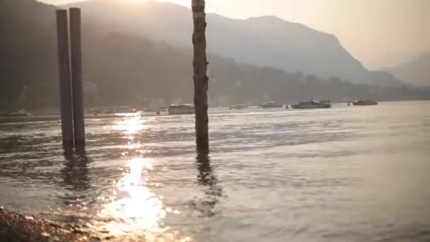 Edificios históricos, olas y yates Salida del sol en el lago de Como en Italia, barcos y una isla — Vídeos de Stock