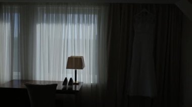 Gelinlik doğal ışık ile bir duvara asılı otel