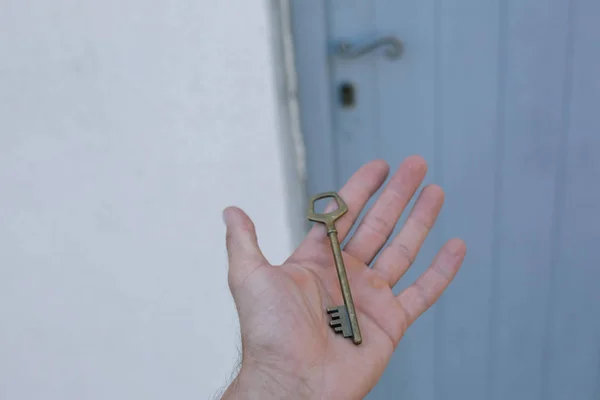 Gammal vintage mässing dörr nyckel i mans hand — Stockfoto