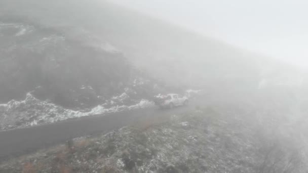 Strada di montagna in Georgia andando al passo in caso di maltempo nella nebbia e neve — Video Stock