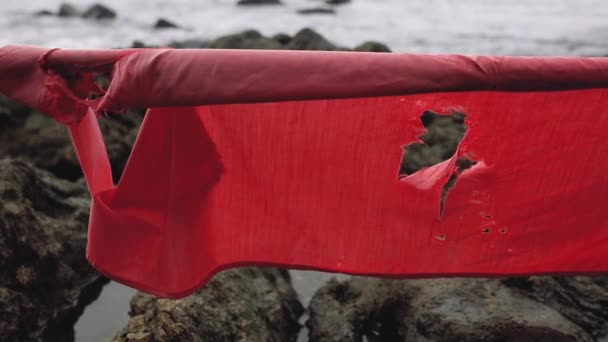 Oude rode ragged vlag op het strand — Stockvideo