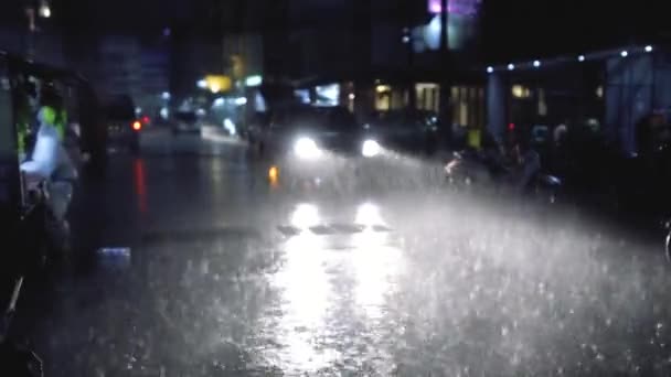 Lluvia fuerte en la ciudad nocturna con luces de coche — Vídeos de Stock