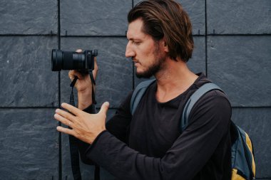 Kamera ve sırt çantası ile genç hipster fotoğrafçı