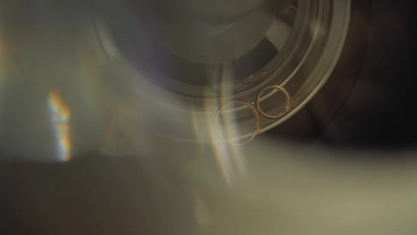 Anelli da sposa in oro macro primo piano lente bagliore sparare diamanti gioielli — Video Stock