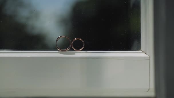 Anéis de casamento de prata na janela com luzes solares chamas de luz macro closeup atirar diamantes Jóias — Vídeo de Stock