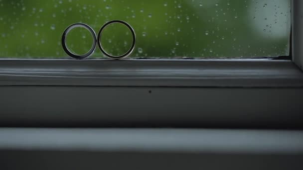 Argent Bagues de mariage sur la fenêtre avec des rayons de soleil fusées éclairantes macro gros plan tige diamon Bijoux — Video