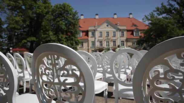 Weiße Stühle und Hochzeitsdekorationen aus weißen und roten Blumen Zeremonie Floristik in der Nähe des Meeres — Stockvideo