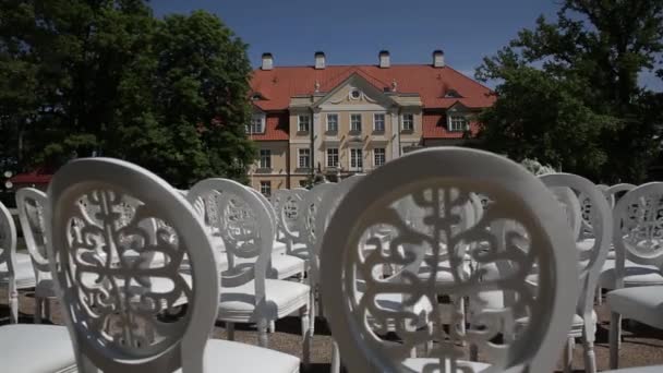 Chaises blanches et décorations de mariage de fleurs blanches et rouges cérémonie floristique près de la mer — Video