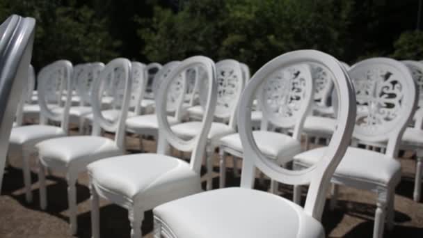 Chaises blanches et décorations de mariage de fleurs blanches et rouges cérémonie floristique près de la mer — Video