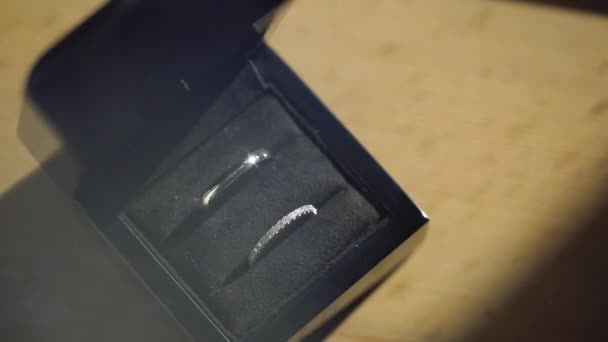 Anéis de casamento de prata na caixa preta macro closeup atirar jóias de diamantes — Vídeo de Stock