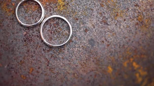 Δαχτυλίδια γάμου σε σκουριασμένο μέταλλο μακρο κοντινά πλάνα χρυσού και αργύρου κοσμήματα σε ηλιακά φώτα — Αρχείο Βίντεο