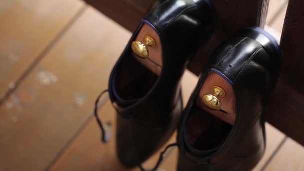 Los zapatos de hombre del novio y el ramo de boda el día de la boda antes de la ceremonia solemne — Vídeos de Stock