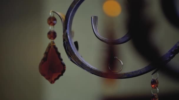 Anneaux de mariage en or macro gros plan lensflare sur une lampe forgée en fer avec tige de cristal diamant Bijoux — Video