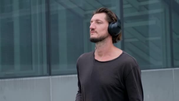 Słuchanie muzyki Freelancer Man w wielkim miejskim mieście pracy z aparatem telefonu laptopa i słuchawek — Wideo stockowe