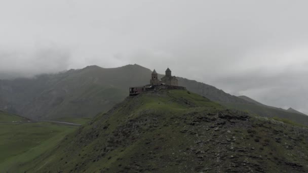 Kazberi miuntains gergeti trinity church in georgia drohnenflug — Stockvideo